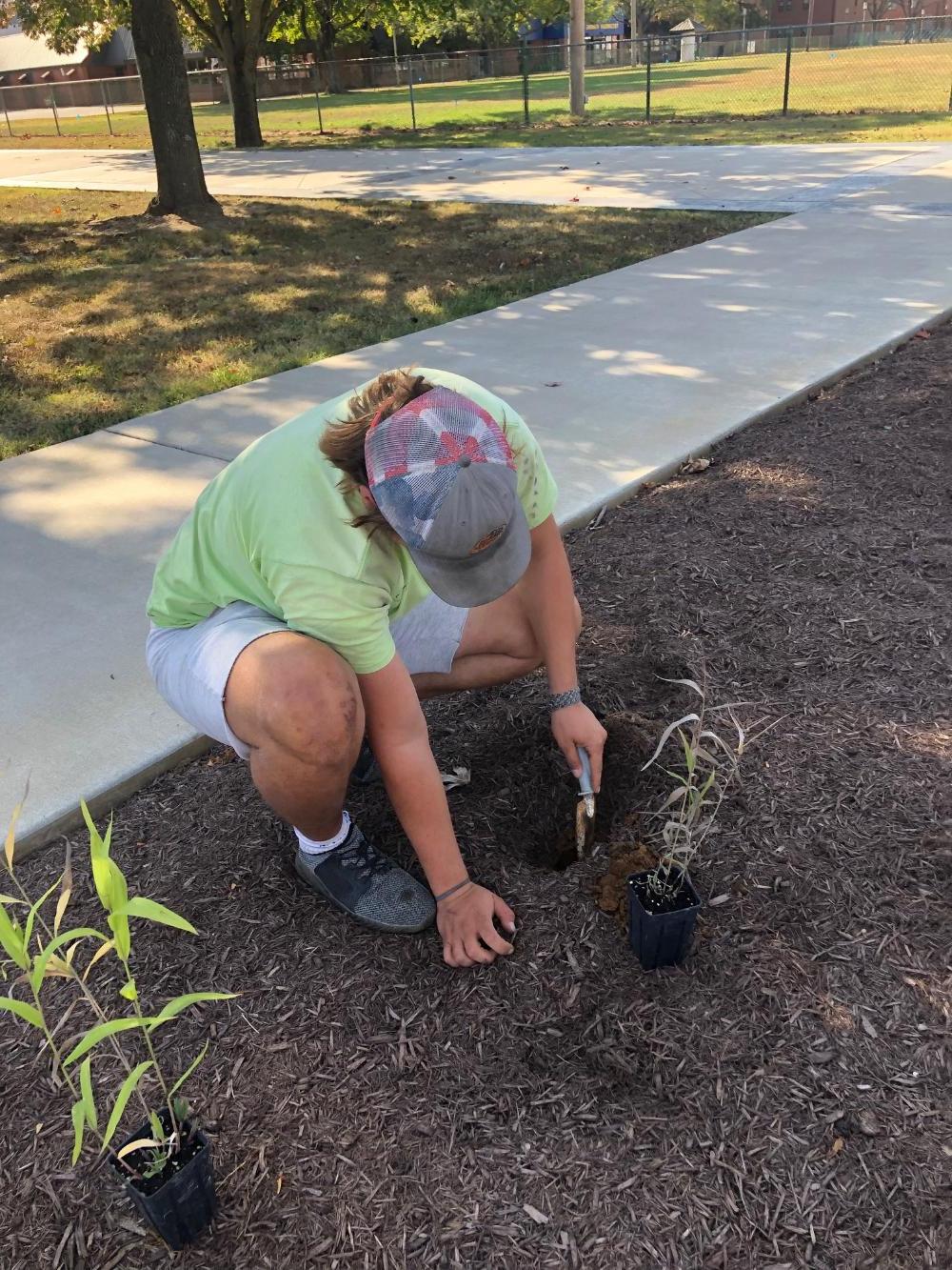 A female geoscience student digging a hole