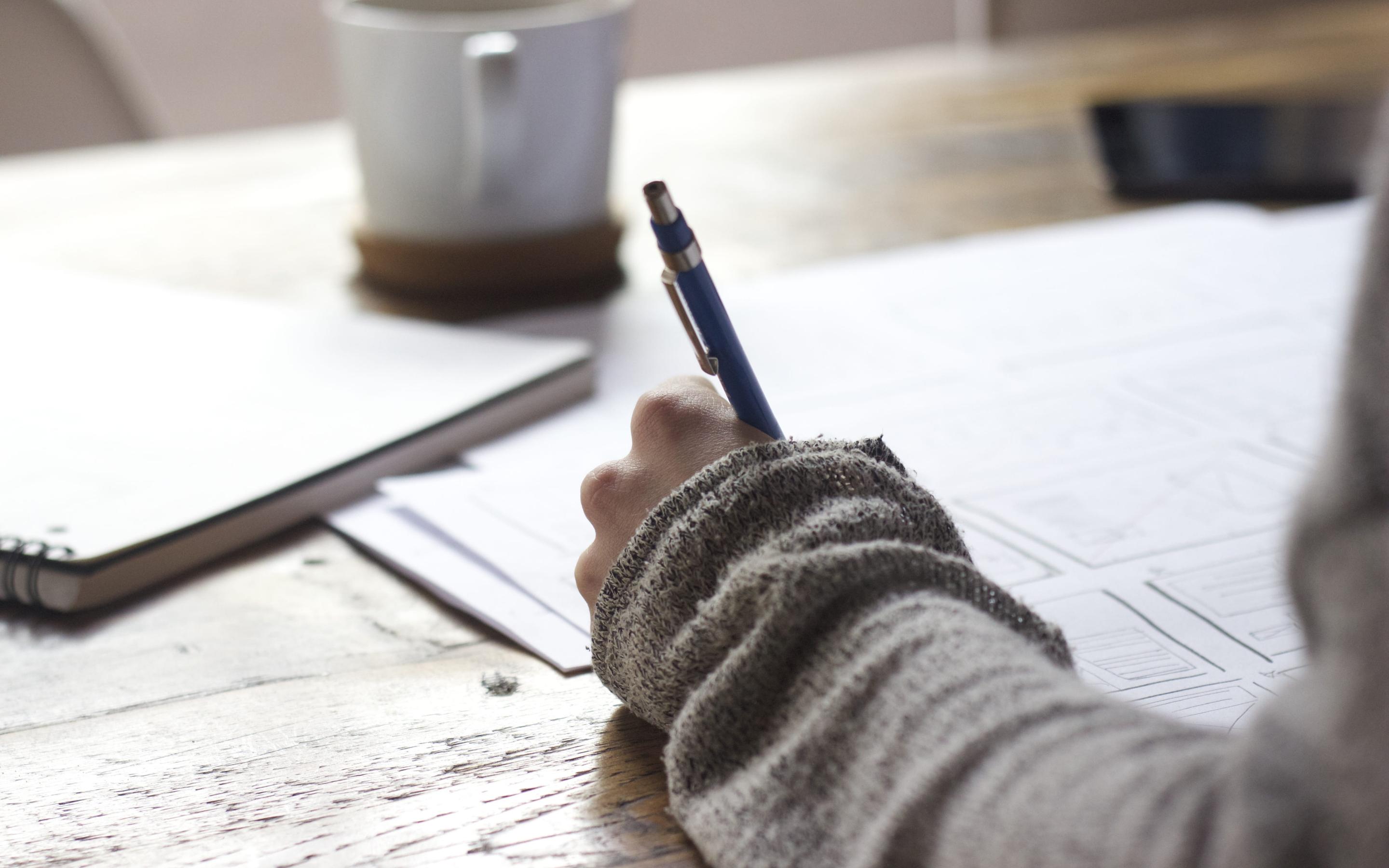 A student using a pen to complete an assignment